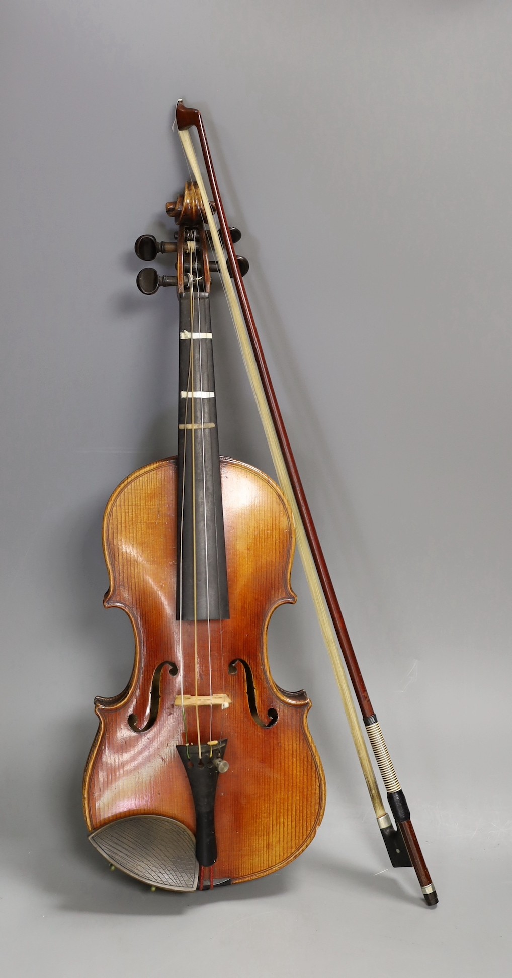 A quarter size late 19th century violin with bow, in E. Hill & Sons case, back measures 29cm